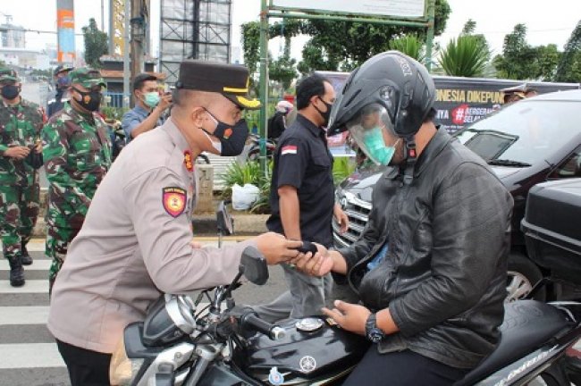 Satlantas Depok Bagikan Masker Kepada Pengendara 